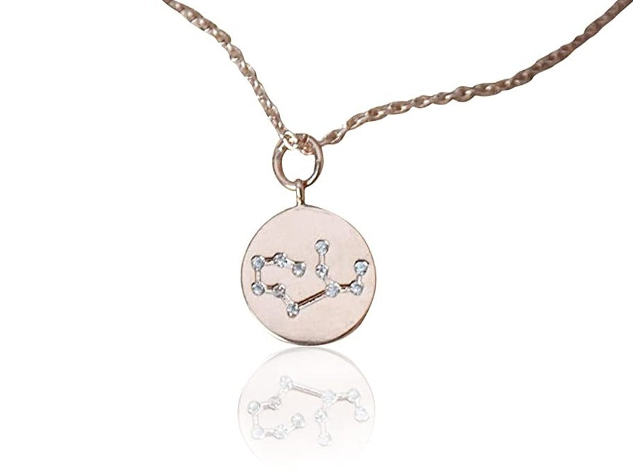 Rose gold necklace with a circular pendant featuring a star design on a white background