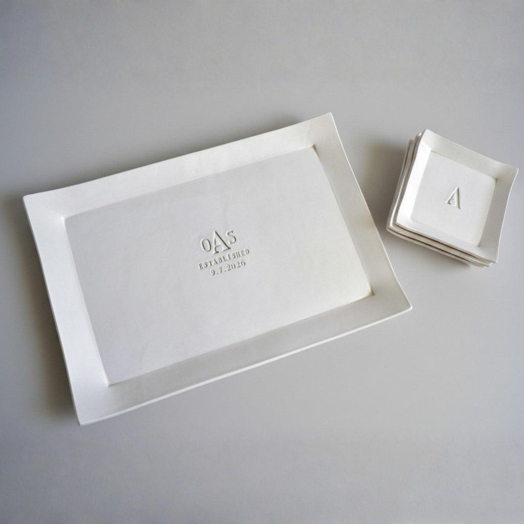 White rectangular tray with engraved initials and date on a gray background