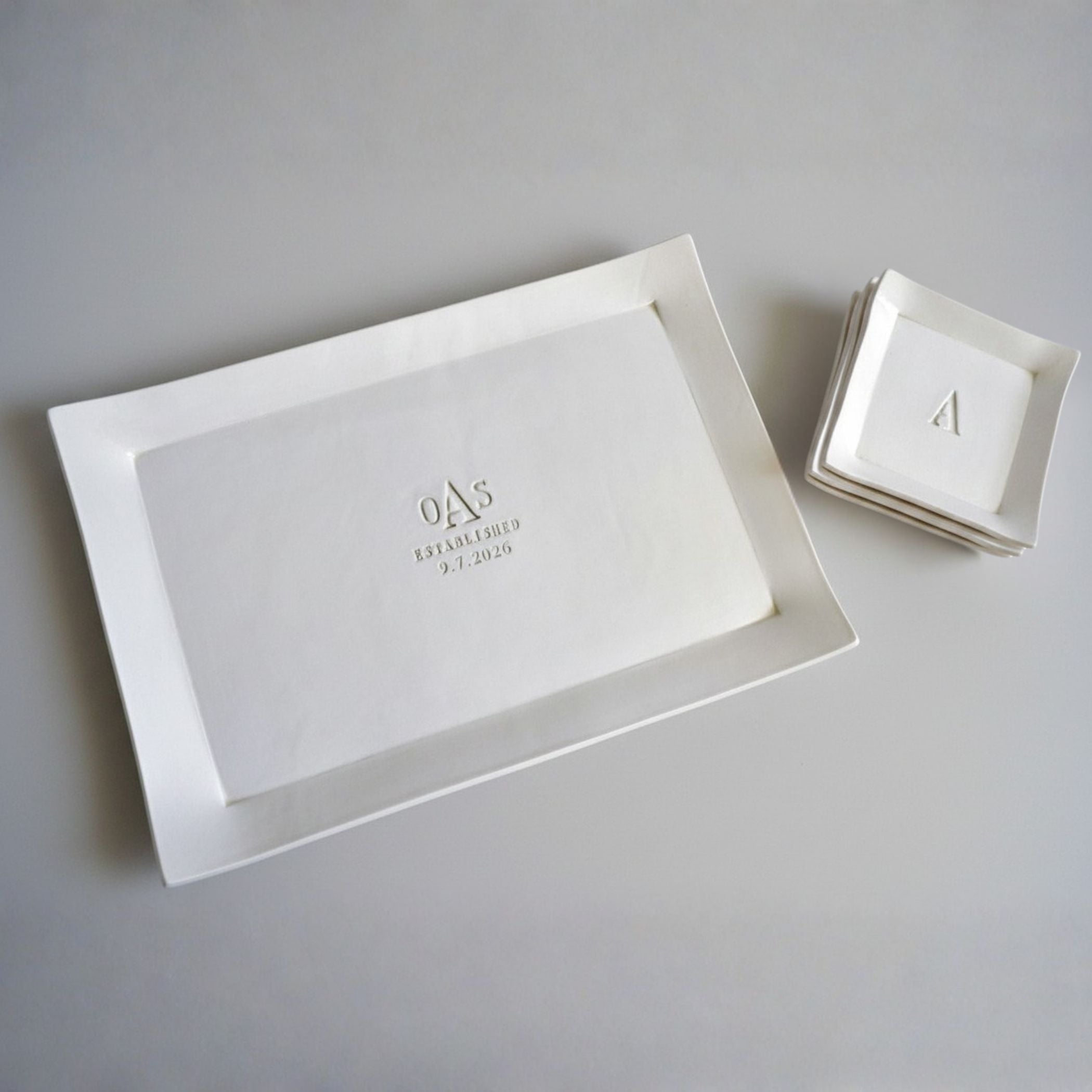 White rectangular tray with engraved initials and date on a gray background