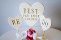 Wedding cake topper with 'Best Day Ever' and 'We Do' hearts
