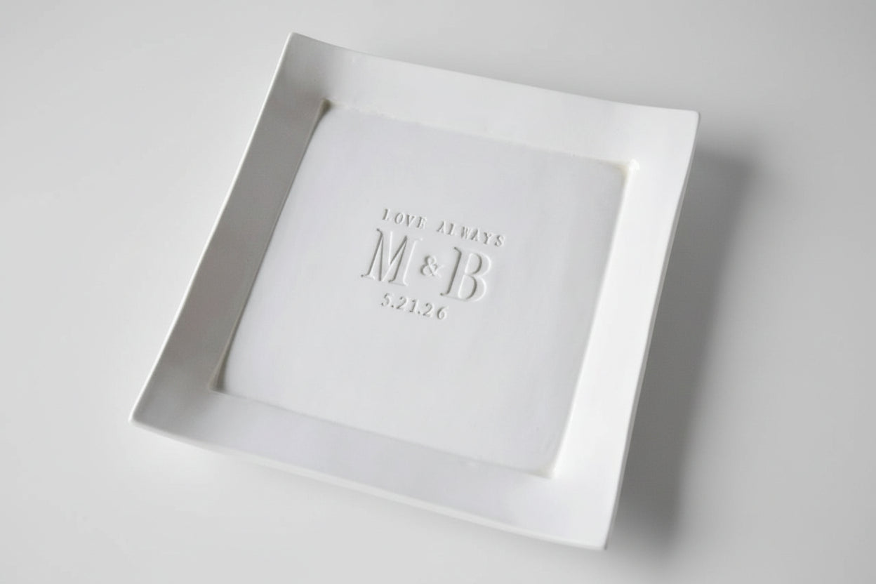 White square plate with 'M&B' debossed on a handmade ceramic