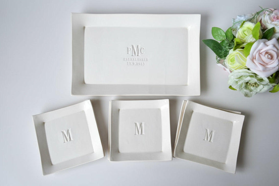 Set of white ceramic dishes personalized with couple's monogram and wedding date